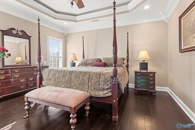 bedroom with a tray ceiling, dark hardwood / wood-style floors, crown molding, and ceiling fan