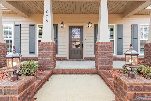 view of exterior entry featuring covered porch