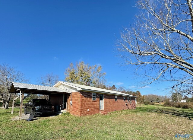 view of side of property with a carport and a yard