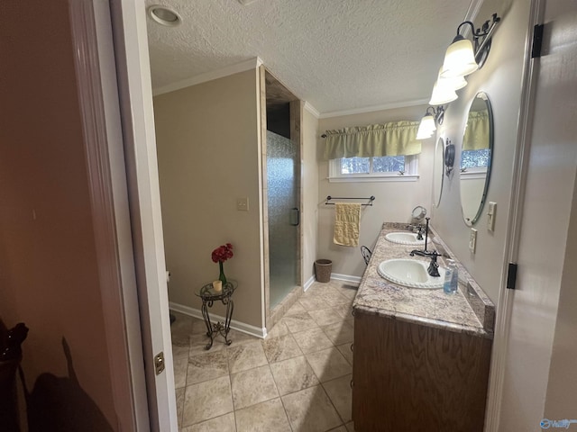 full bathroom with double vanity, a stall shower, a textured ceiling, and a sink