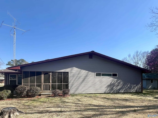 view of side of property with a yard and a sunroom