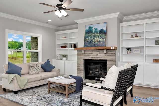 living room with ornamental molding, a fireplace, and light hardwood / wood-style flooring