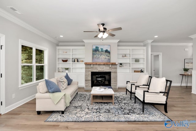 living room with a fireplace, ceiling fan, light wood-type flooring, and ornamental molding