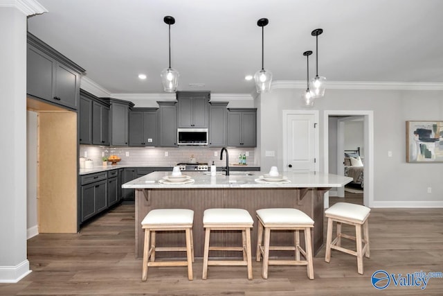 kitchen with a kitchen island with sink, dark hardwood / wood-style floors, and gray cabinetry