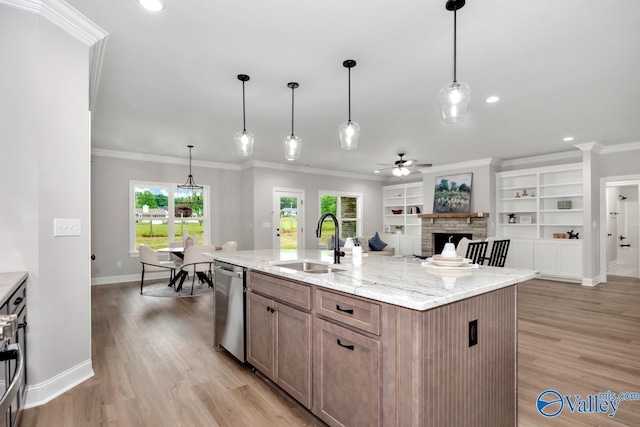 kitchen featuring stainless steel dishwasher, sink, a healthy amount of sunlight, and a center island with sink