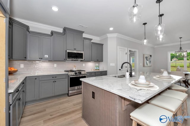 kitchen featuring sink, a kitchen island with sink, a kitchen breakfast bar, and stainless steel appliances