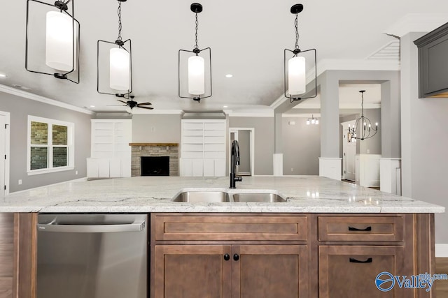 kitchen featuring stainless steel dishwasher, a stone fireplace, sink, and crown molding