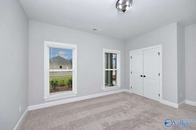 interior space with a wealth of natural light and light colored carpet