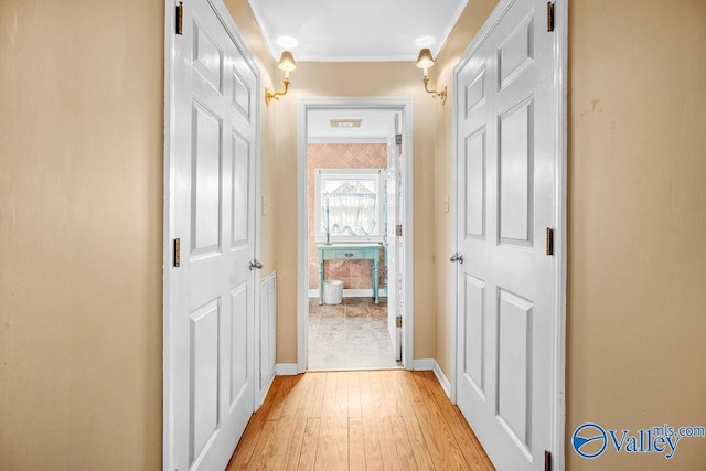 hallway with baseboards and light wood-style floors