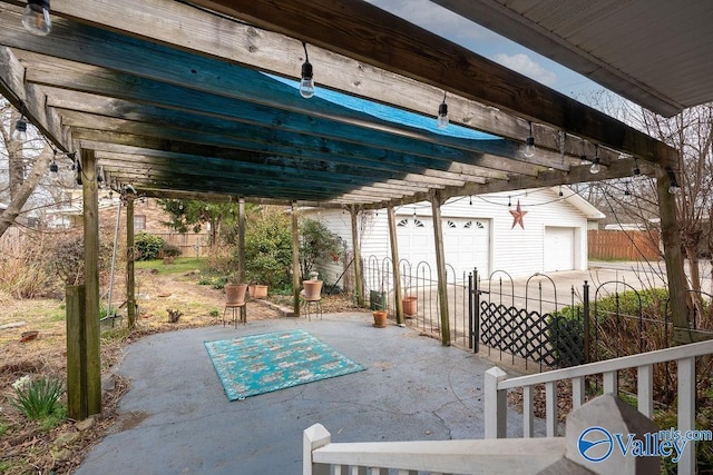 view of patio with an outbuilding, a garage, and fence