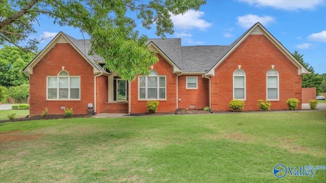 ranch-style house featuring a shingled roof, a front lawn, and brick siding