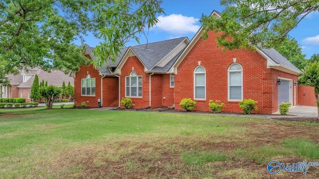 view of front facade featuring an attached garage, brick siding, and a front yard