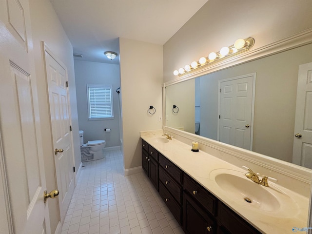 bathroom with toilet, tile patterned flooring, double vanity, and a sink