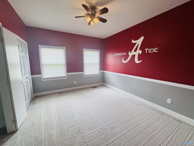 unfurnished bedroom with ceiling fan, carpet, baseboards, and visible vents