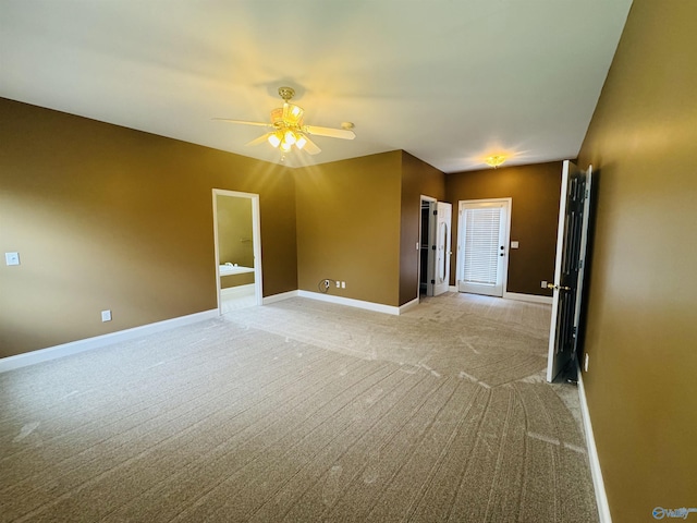 empty room featuring light colored carpet, baseboards, and a ceiling fan