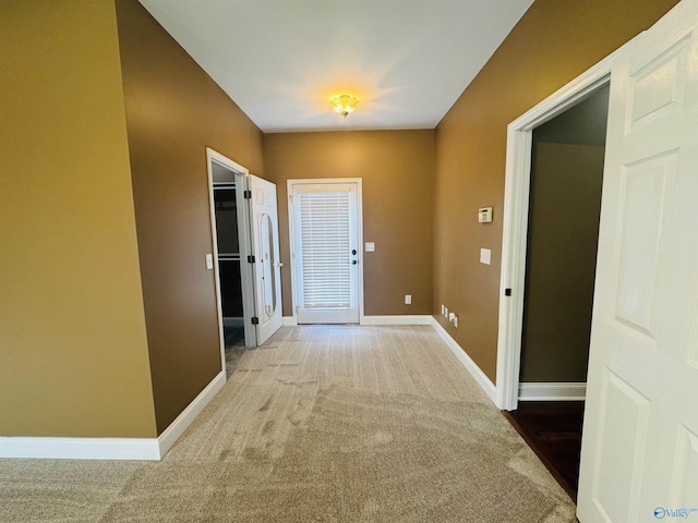 hallway with carpet flooring and baseboards