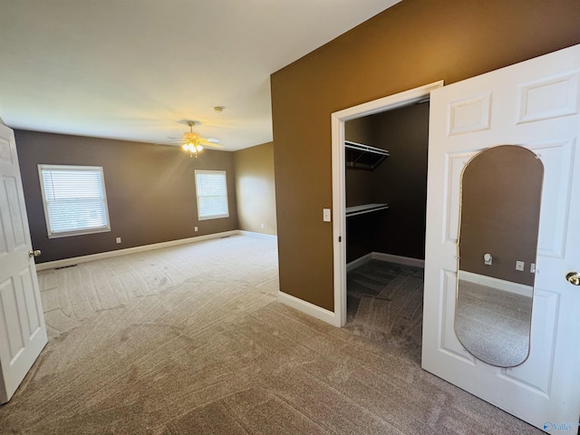 interior space with baseboards, carpet flooring, and ceiling fan