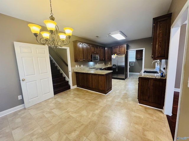 kitchen with dark brown cabinets, a sink, a peninsula, a chandelier, and stainless steel appliances