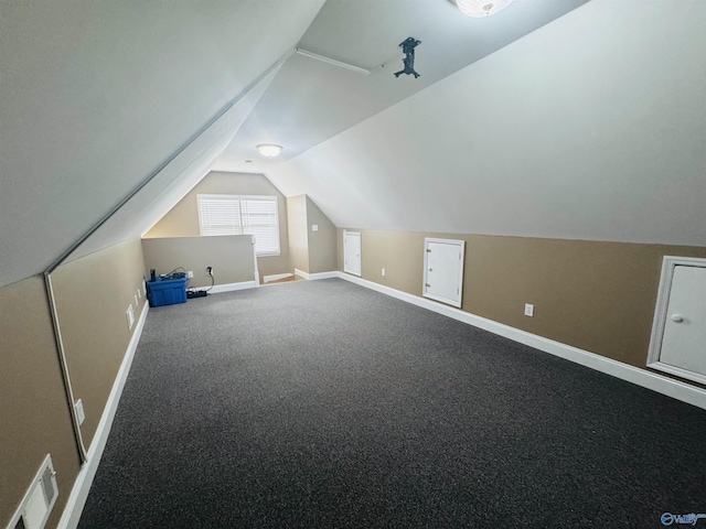additional living space with vaulted ceiling, carpet, baseboards, and visible vents