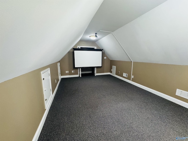 bonus room with lofted ceiling, baseboards, visible vents, and dark carpet