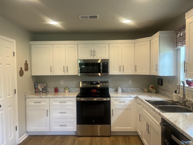 1006 SW 6th St, Attalla, AL 35954 - kitchen featuring stainless steel appliances, a sink, white cabinets, dark wood-style flooring, and light stone counters