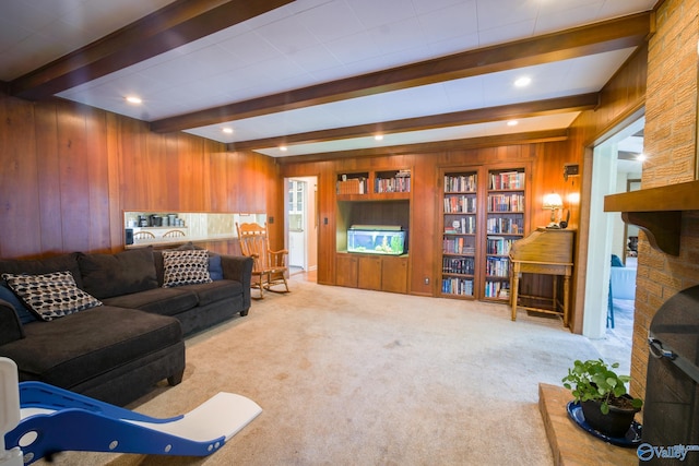 carpeted living room with beamed ceiling and wooden walls