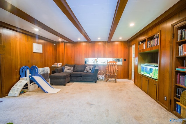 living room featuring beamed ceiling, light colored carpet, and wooden walls