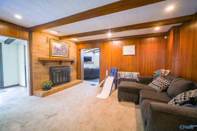 carpeted living room featuring beamed ceiling and wooden walls