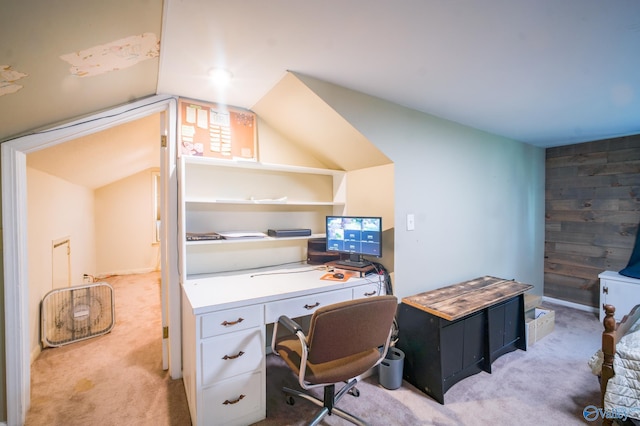 carpeted home office featuring vaulted ceiling