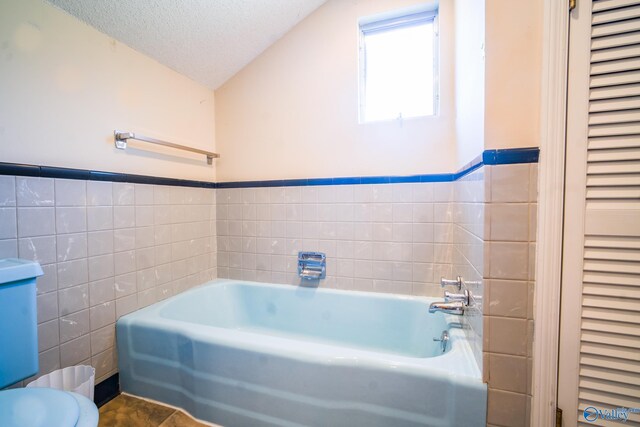 bathroom featuring tile walls, tile patterned floors, toilet, and a textured ceiling