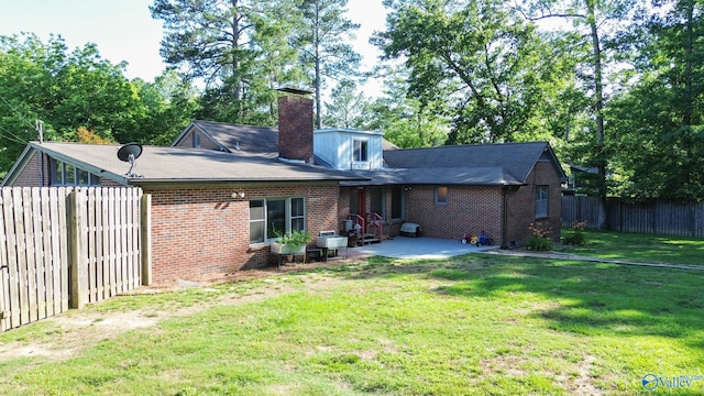 back of property with a yard and a patio area