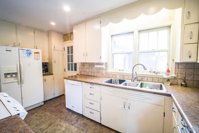 kitchen featuring dark tile patterned floors, a wealth of natural light, backsplash, and white appliances