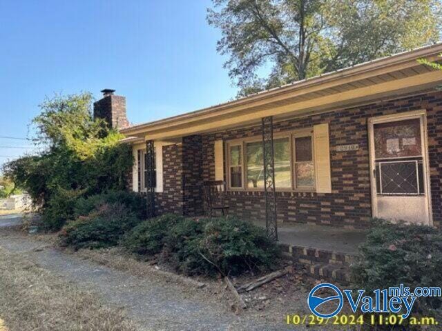 view of side of property featuring brick siding and a chimney