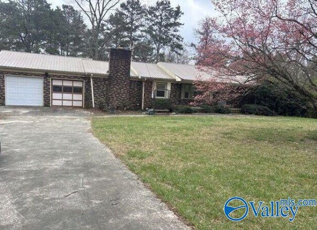 2940 Fairview Rd, Gadsden, AL 35904 - single story home with a chimney, asphalt driveway, an attached garage, a front yard, and metal roof