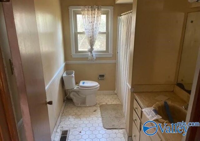 bathroom with tile patterned flooring, vanity, and toilet