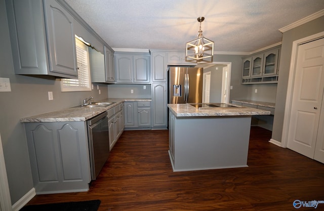 kitchen featuring gray cabinetry, appliances with stainless steel finishes, a kitchen island, decorative light fixtures, and crown molding