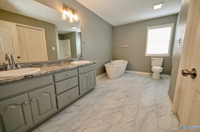 bathroom with vanity, a bathtub, and toilet