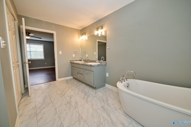 bathroom with vanity, a washtub, and ceiling fan