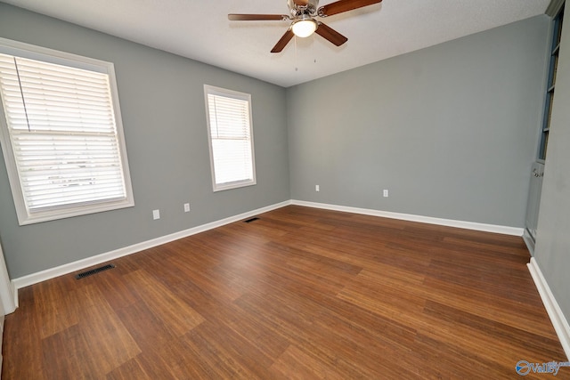 empty room featuring ceiling fan and dark hardwood / wood-style flooring