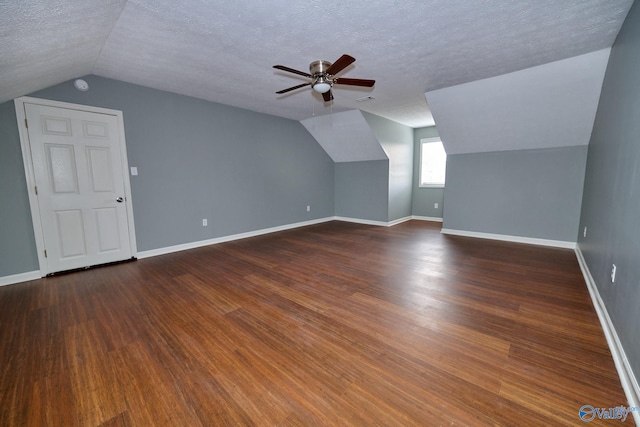 additional living space with ceiling fan, a textured ceiling, lofted ceiling, and dark hardwood / wood-style floors