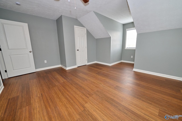 bonus room featuring lofted ceiling, hardwood / wood-style floors, a textured ceiling, and ceiling fan