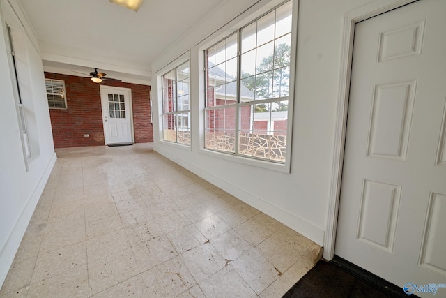 unfurnished sunroom with ceiling fan