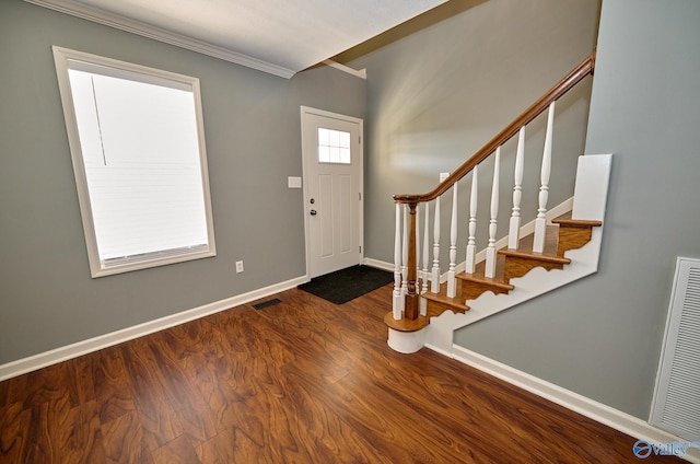 entrance foyer with ornamental molding and dark hardwood / wood-style flooring