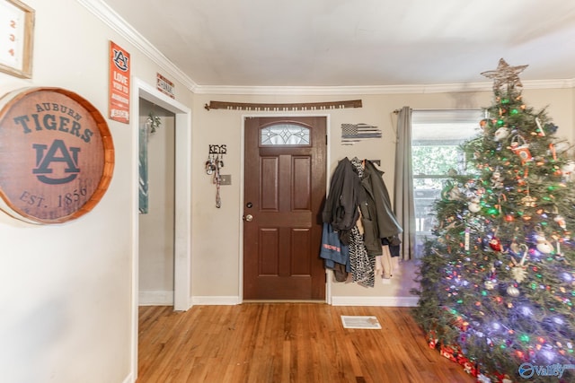 entryway with crown molding and light wood-type flooring