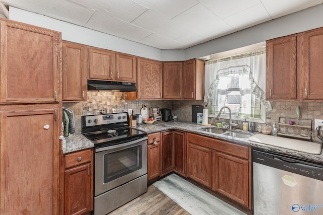 kitchen featuring sink, decorative backsplash, light hardwood / wood-style flooring, and appliances with stainless steel finishes