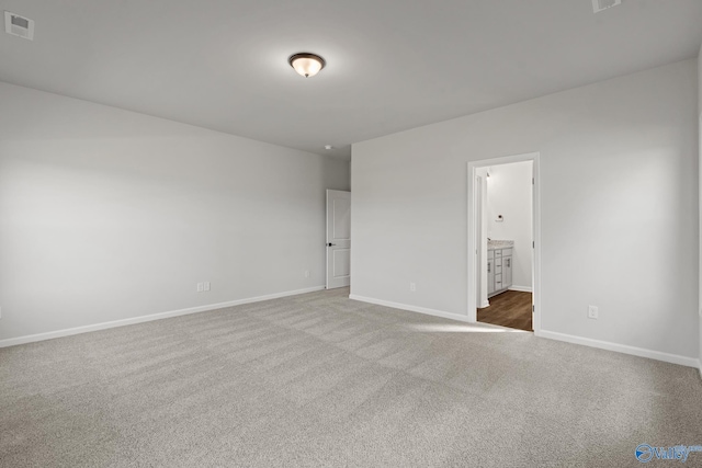 unfurnished bedroom featuring carpet and connected bathroom