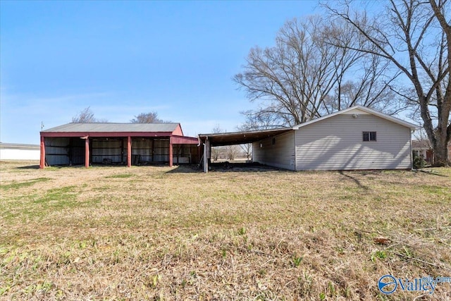 exterior space with a carport and a lawn