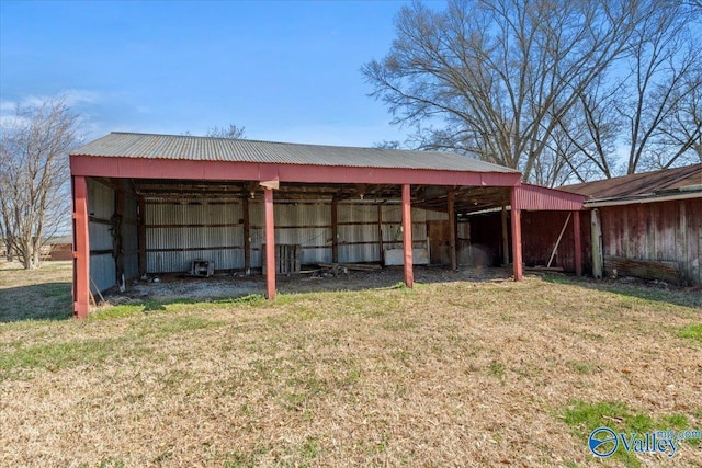 view of pole building featuring a yard, a carport, and driveway