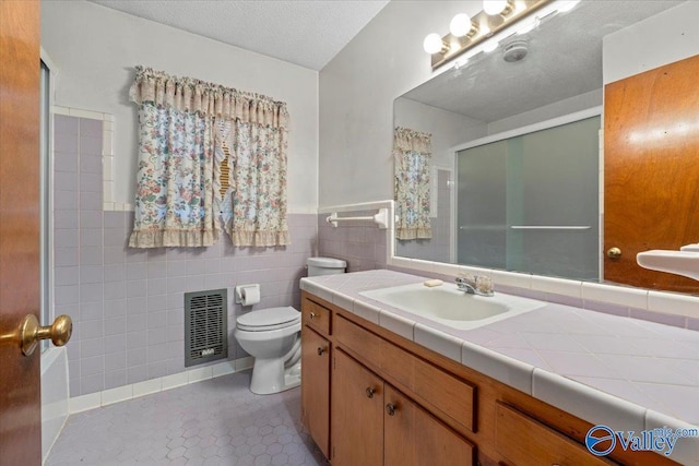 full bath with visible vents, toilet, tile patterned floors, a shower stall, and tile walls