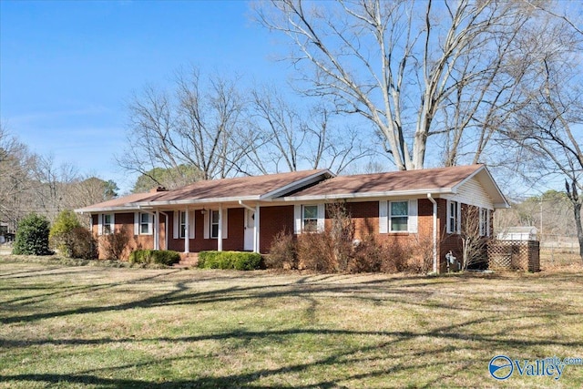 single story home with covered porch, brick siding, a chimney, and a front yard